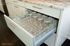 an open drawer with wine glasses in it