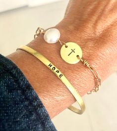 "This dainty paperclip chain bracelet is crafted with a hand stamped cross pendant accented with a classic pearl. It is fabulous on it's own or stacked with other bracelets. The circle cross pendant is 1/2\" in diameter. Total overall length is 7 1/2\" which fits most adult women's wrists and can easily be adjusted by fastening the clasp in a different chain link. If you need smaller or larger total length, please let me know at checkout. I can shorten the length to fit a child's wrist. NOTE: The hand stamped 1/8\" hammered and hand stamped cuff bracelet shown in this listing is available in a separate listing here:  https://www.etsy.com/listing/1126078071/dainty-cuff-bracelet-18customizableword?click_key=cdafae25c27f484324147f9a3d11824b47490ccf%3A1126078071&click_sum=b96799bc&ref=shop_hom Everyday Metal Cross Jewelry, Adjustable Cross Chain Bracelet As Gift, Inspirational Adjustable Gold Charm Bracelet, Inspirational Hypoallergenic Everyday Jewelry, Everyday Inspirational Hypoallergenic Jewelry, Inspirational Everyday Hypoallergenic Jewelry, Adjustable Personalized Paperclip Bracelet For Everyday, Adjustable Personalized Paperclip Bracelet, Personalized Adjustable Paperclip Bracelet For Everyday