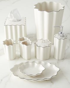 a white bathroom set with soap dispenser, toothbrush holder and cups