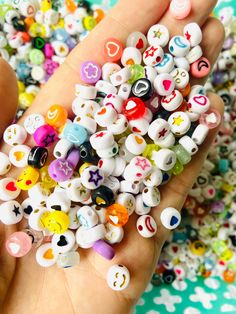 a person is holding some small beads in their hand and it looks like they have eyes on them