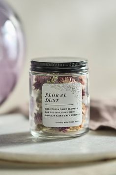 a jar filled with flowers sitting on top of a table