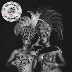 two women dressed in costumes and headdress posing for the camera with their arms around each other