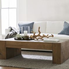 a living room with a white couch and wooden coffee table