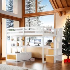 a loft bed with desk underneath it in front of a window overlooking the snow covered trees