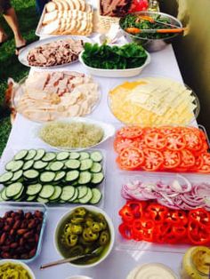 a long table filled with lots of different types of food on plates and bowls next to each other