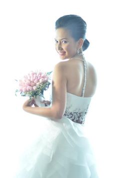 a woman in a white dress holding a bouquet of flowers