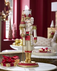 a nutcracker figurine is standing on a table with presents around it