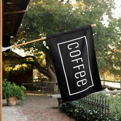 an open sign hanging from a clothes line on the side of a building with trees in the background