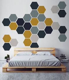 a bed sitting in front of a wall with hexagonal shapes on it