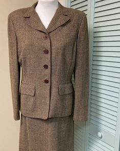 "True vintage plaid skirt and jacket suit in a wool blend brown fabric.  Jacket features shoulder pads, 2 front flap pockets, front darts and lining. Skirt has waist darts, side metal zipper and generous hem. lined with crepe in the back seat area only.  Best fit would be a medium/ large but please check measurements below.  * Condition notes- there are a few small darns here and there that you have to look hard to find due to the plaid pattern.  There is some wear and discoloration at the back Classic Winter Skirt Suit With Button Closure, Winter Classic Skirt Suit With Button Closure, Classic Tweed Skirt Suit For Fall, Classic Single Breasted Skirt Suit For Fall, Brown Long Sleeve Skirt Suit For Work, Brown Skirt Suit For Fall, Fitted Brown Tweed Jacket For Office, Fall Brown Long-sleeved Skirt Suit, Fall Long Sleeve Brown Skirt Suit