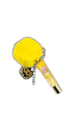 a yellow pom - pom keychain with a gold snake on it