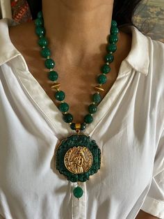 One of a kind, One time piece. Elevate your style with our premium pendant necklace set. Crafted to perfection, this set exudes timeless beauty and unmatched quality, ensuring you stand out on every occasion. Product Details: Material: Meticulously crafted from high-quality materials such as Green Agate Beads, Brass, Copper, Gold Polish, Carved Agate Stone. This necklace set combines durability with a brilliant, enduring shine. Necklace Dimensions: Weight: 180 grams Drop Length: 11 inches. Closu Temple Jewelry Gemstone Round Pendant Necklace, Temple Jewelry Necklace With Round Gemstone Pendant, Emerald Pendant Necklace With Detachable Pendant As Gift, Temple Jewelry Style Emerald Gemstone Necklace As Gift, Emerald Necklace For Gift In Temple Jewelry Style, Emerald Necklace With Detachable Pendant Gift, Emerald Gemstone Necklace For Gift, Temple Jewelry Style, Temple Jewelry Style Emerald Pendant Necklace, Gift Emerald Necklace With Detachable Pendant