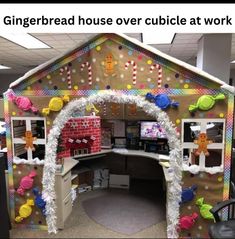 the gingerbread house over cubicle at work is decorated with candy canes and gummy bears