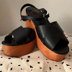 Questions? Leave A Comment Below! Black Round Toe Clogs For Vacation, Chic Wedge Sandals With Wooden Heel And Ankle Strap, Chic Ankle Strap Wedge Sandals With Wooden Heel, Black Open Toe Clogs For Summer, Black Open Heel Clogs For Summer, Black Wedge Heel Clogs For Summer, Black Clogs For Summer Parties, Black Platform Wedge Slingback Sandals, Black Slingback Sandals With High Wooden Heel