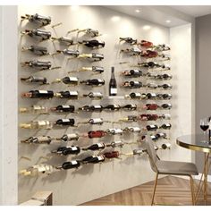 a wall mounted wine rack filled with lots of bottles next to a dining room table