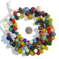 multicolored glass bead necklace with coin on white background, close up photo