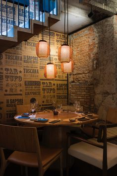 a dining room with wooden tables and chairs next to a stair case that has advertisements on it