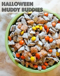 a green bowl filled with halloween muddy buddies