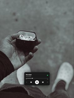 a person holding an object in their hand and listening to music on the other side