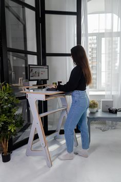 a woman standing at a desk using a computer