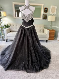 a black and white dress on display in a living room with a couch, chair and mirror