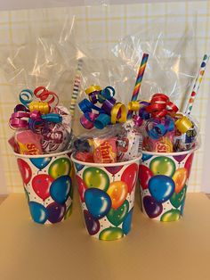 three buckets filled with candy and balloons