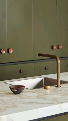 a kitchen sink sitting under a faucet on top of a marble countertop