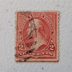 an old red and black stamp with a man's face on the bottom corner