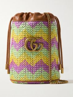 Gucci's bucket bag is patterned with chevron stripes in vibrant, summer-inspired tones. Made from straw, it's reinforced with leather trims and topped with the house's iconic 'GG' emblem. It's perfectly sized to fit your phone, keys and sunglasses and has internal slots for your most-used cards. Gucci Bucket Bag With Leather Handles, Gucci Multicolor Tote Bag, Designer Gucci Bucket Bag, Multicolor Bucket Bag With Dust Bag, Gucci Bucket Bag With Dust Bag, Gucci Bucket Shoulder Bag For Travel, Multicolor Gucci Bags, Multicolor Gucci Shopping Bag, Gucci Bucket Bag For Shopping