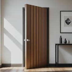 an open door in a white room next to a table with vases on it