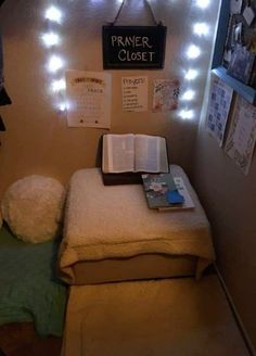 a small bed with a book and some lights on the wall