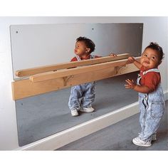 two small children standing in front of a mirror