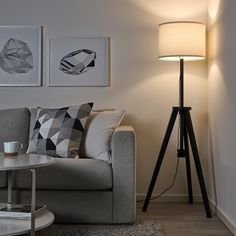 a living room with a couch, lamp and pictures on the wall