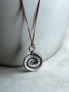 Hand-Forged Spiral Necklace -  Protect Your Spirit with Iron EleganceDiscover the blend of ancient lore and modern craftsmanship with this authentic hand-forged Spiral  necklace. Created using traditional blacksmithing techniques (hammer and anvil), each necklace carries with it a piece of history and the mark of individuality. Key Features: 🛠️  Handcrafted Excellence: Forged by hand for a unique, one-of-a-kind design. ⚒️ Material Integrity: Made with high-quality iron to ensure durability and longevity. 🎨 Aesthetic Appeal: Rustic, timeless design that complements any attire, from casual to formal. Product Details: Pendant Size: Approximately 2 inches in height.Necklace Length: Adjustable leather cord for comfort and versatility. Color: Natural polished iron with a subtle patina for an a Blacksmith Forge, Iron Jewelry, Spiral Necklace, Amulet Necklace, Necklace Charm, Handmade Necklace, Blacksmithing, Hand Forged, Necklace Length