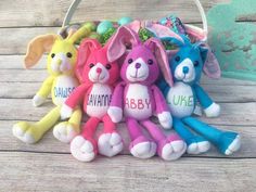 several stuffed animals are sitting in a row on a wooden table, with the word ube painted on them