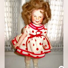 the doll is wearing a red and white dress with polka dots on it's skirt