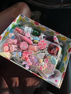 a box filled with lots of different types of buttons and pins on it's side