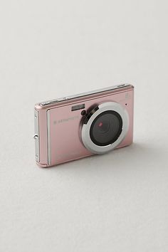 a pink camera sitting on top of a white table