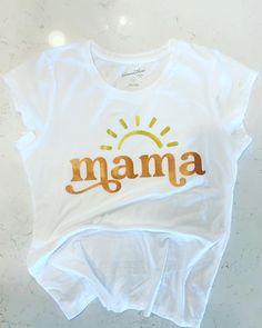 "This Mama  shirt is perfect to wear to match your \"First Trip Around The Sun\" or even just to show your true Sunshine self! Made with our no shed glitter its sure to be a hit. Shirt: Cotton Washing: Turn inside out and wash on cold !!Don't forget to follow us on Facebook and Instagram!!" Gold T-shirt With Letter Print For Summer, Gold Cotton Tops With Logo Print, Gold Letter Print Top For Summer, Gold Letter Print Tops For Summer, Gold Graphic Print Top For Birthday, Gold Top With Graphic Print For Birthday, Summer Slogan Top For Birthday, White Slogan Top For Mother's Day, Gold Top With Graphic Print