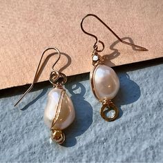 These Handmade Gold Fill Hoop Earrings Have A Subtle Asymmetrical Design And A Wire Wrap That Accentuates The Unique Shape Of Each Pearl. They Measure 1.25 Inches Long. Made With High Quality 12-14k Gold Fill With A Jeweler’s Brass Core. Elegant Rose Gold Wire Wrapped Earrings, Elegant Wire-wrapped Yellow Gold Pearl Earrings, Elegant Wire Wrapped Earrings For Formal Occasions, Elegant Yellow Gold Wire Wrapped Pearl Earrings, Formal Teardrop Wire Wrapped Earrings, Gold Wire Wrapped Earrings For Formal Occasions, Formal Gold Wire Wrapped Earrings, Elegant White Single Wrap Earring, Gold Pearl Earrings With Ear Wire For Fine Jewelry