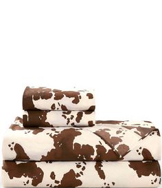 the brown and white cow print sheets are folded on top of each other