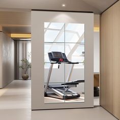 an exercise room with a treadmill in the middle and a large window to let in light