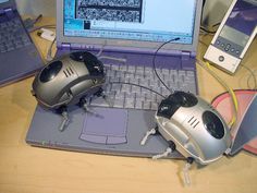 two computer mice sitting on top of a laptop