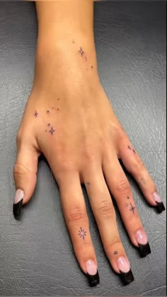 a woman's hand with small stars on it