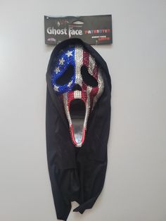 a mask with the american flag painted on it's face is hanging up against a wall