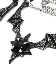 Made to Order! Dramatic, imposing and vampiric as you are, this bat wing necklace will complete your nocturnal ensemble. Stalk the halls of your dwelling or favorite events and capture the attention of your fellow night creatures with its unique design, sculpted in our studio. The pendant is cast in lead free pewter by hand and weathered, then set with a glass or stone cabochon. The chain is accented with hand beaded elements for a finishing touch. It can be layered with one of my rosary chains, or shorter pieces like chokers! Its also perfect on its own with all kinds of outfit choices as a centerpiece. Available in multiple variants Necklace chain default length: 18 in If you'd like a different chain length, please leave a note with your order Time to make and ship: 1-2 days. Adjustable Vampire Necklace For Halloween, Vampire Style Necklace For Halloween, Vampire Style Necklaces For Halloween Cosplay, Black Necklace For Halloween Cosplay, Black Jewelry For Halloween Fantasy Events, Black Gothic Necklace For Fantasy Events, Gothic Horned Jewelry For Halloween, Gothic Black Necklace For Fantasy Events, Black Gothic Jewelry For Fantasy Events