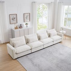 a large white couch sitting in a living room on top of a hard wood floor