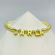 Make a stylish statement with the Luxe Beaded Name Bracelet. Embellished with shiny gold beads and refined letter charms, this bracelet can be customized with your name or a unique word, making it a timeless addition to any collection. Unique Words, Custom Earrings, Name Bracelet, Letter Charms, Custom Bracelets, Custom Necklace, Gold Beads, Custom Rings, Ring Bracelet