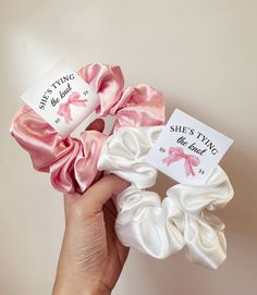 three scrunffle hair ties in pink and white with saying she's tying the knot