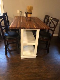 a kitchen table with two chairs and a shelf on the top that is built into the floor